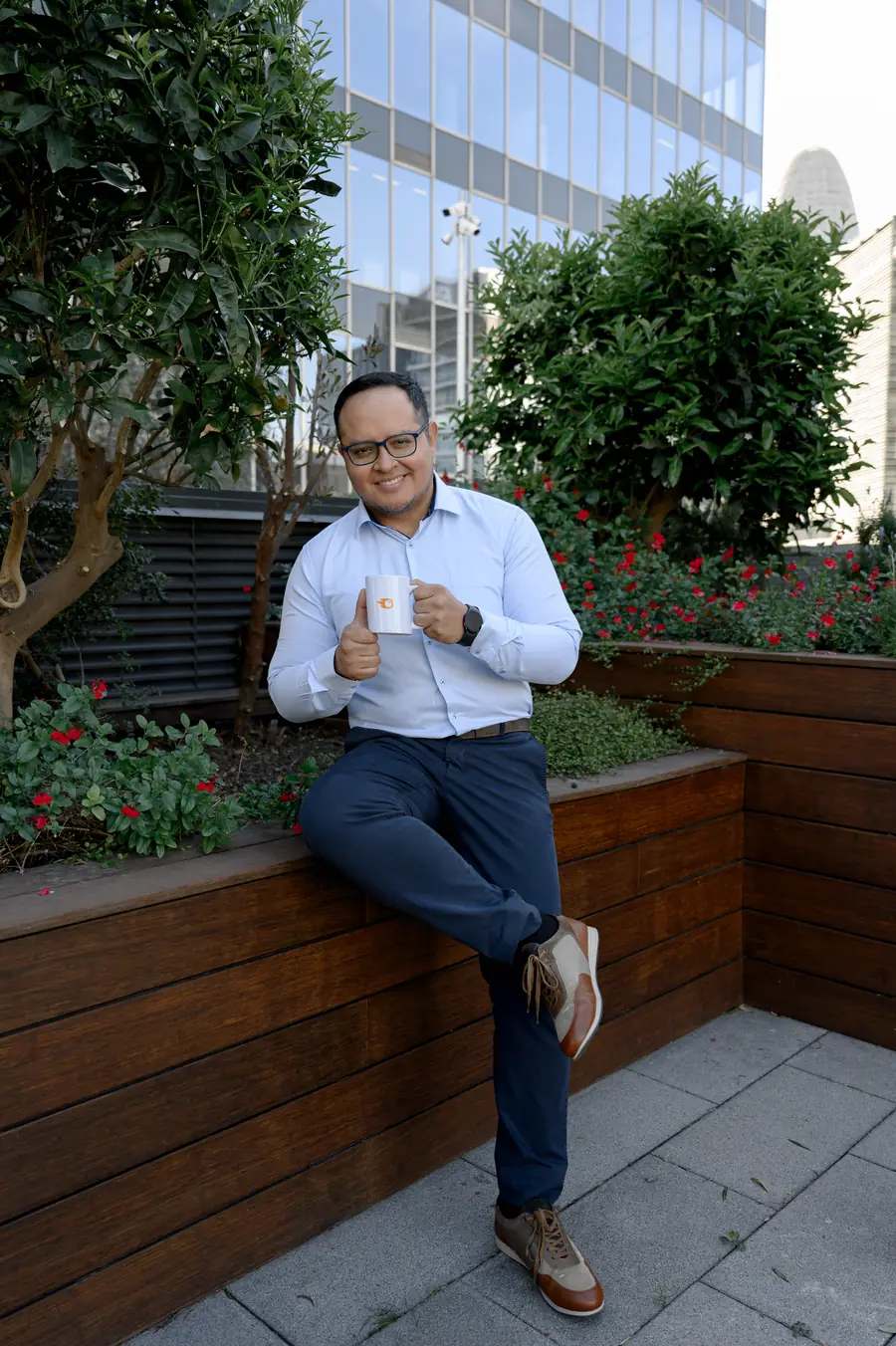 Fernando outdoors with coffee, casual workday moment