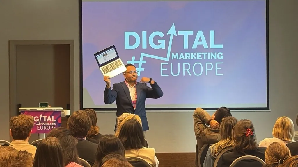 Fernando Angulo holding a laptop displaying a slide after AV failure at Digital Marketing Europe 2026