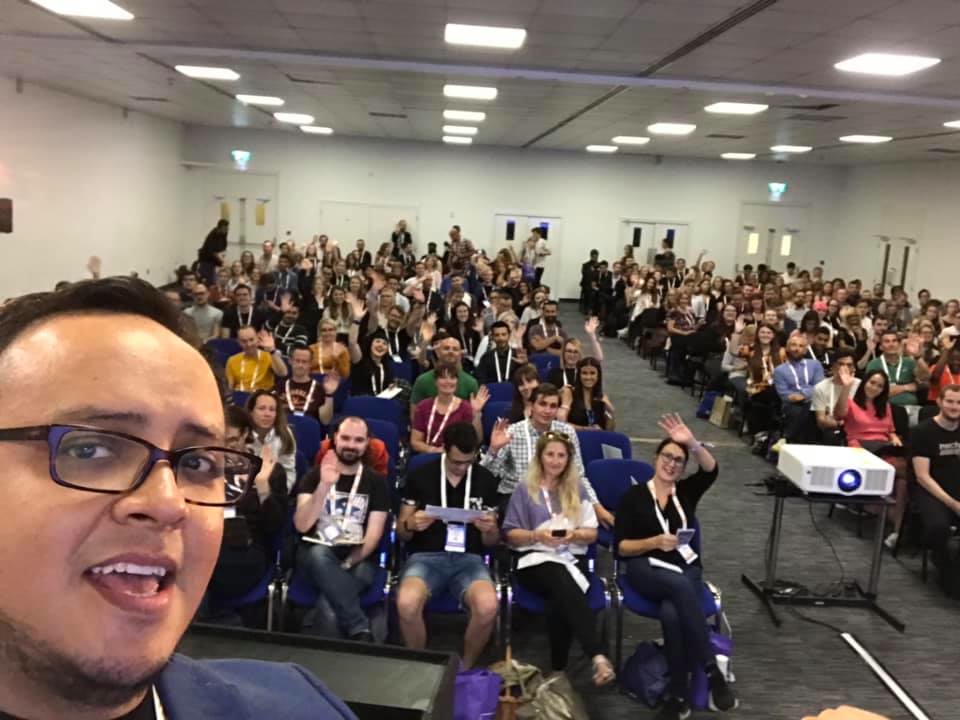 Fernando Angulo taking a photo with a full conference audience